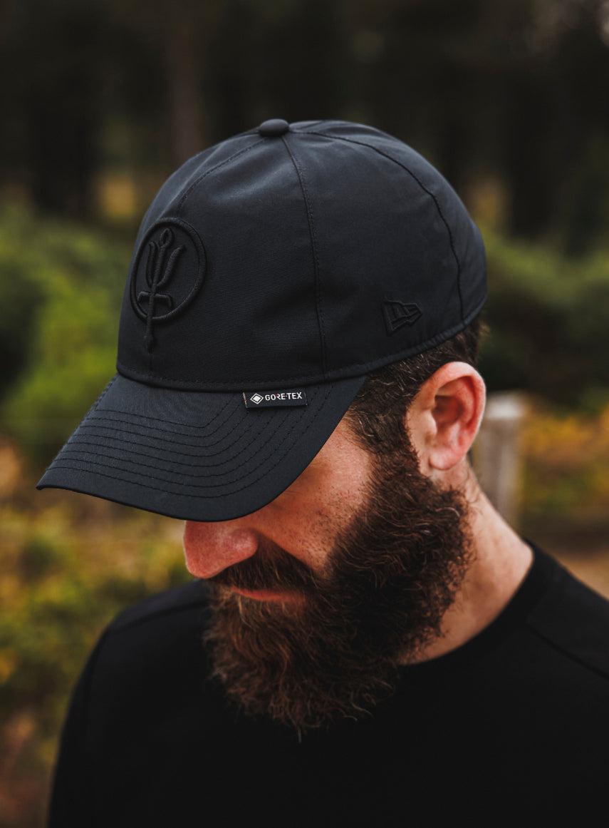 An in the field image of Men's New Era Desert Gore-Tex 9twenty Cap in Obsidian Black (ITF)