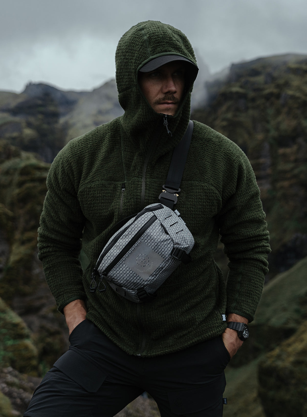 An in the field image of Phalanx Hooded Fleece in Forest Green (ITF)